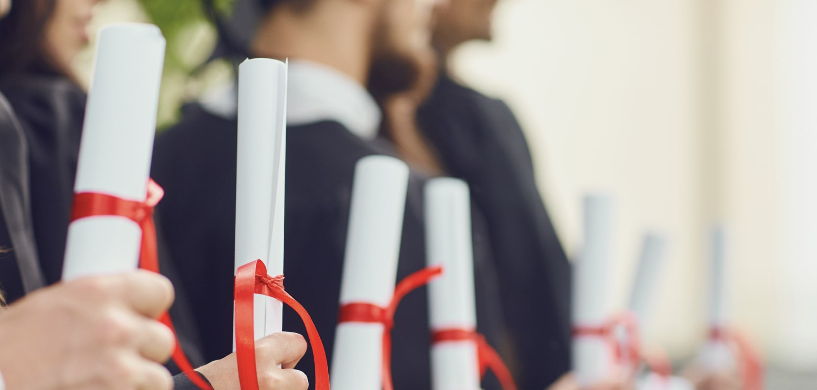 students at graduation holding diplomas